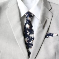 An upbeat floral pattern adds an instant lightheartedness to any event, and our bow tie is guaranteed to liven up your look. Tie Mood adult bow ties are double-deck (two layers), have a sturdy loop and clasp to ensure a snug and comfortable fit.   Adult Necktie:  approximately 2.25 inches wide and 58 inches long Adult Pre-tied Bow Tie - The strap is adjustable to fit neck sizes from 12-21 inches. This size should fit most teens/adults from 13 years and up. The bow is approx. 4.5 inches wide and 2.75 inches height. Child Pre-Tied Bow Tie:  approx. 4 inch width and 2 inch length - Necksize 11 inches - 19 inches    Plastic clasp for each wear and removal. Pocket Square: approximately 9 inches x 9 inches Color:  Navy Dark Blue Floral Material:  100% Cotton www.tie-mood.com Blue Floral Print Suit And Tie Accessories For Business, Fitted Blue Floral Suit And Tie Accessories, Summer Ties For Groom, Spring Suits For Grooms, Blue Floral Print Suit And Tie Accessories For Spring, Floral Print Suit And Tie Accessories For Spring Business, Elegant Floral Print Suit And Tie Accessories For Groom, Spring Blue Floral Print Suit And Tie Accessories, Summer Floral Print Ties