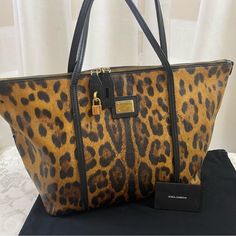 Authentic D & Gabbana Tote Bag, "Miss Escape" Collection, Leopard Print, Zipper Closure , Gold Tone Hardware, Zipper Pocket Inside, Black Leather Trim, Preowned, Regular Sign Of Wear, No Rips Or Tears, Very Good Condition. Designer Rectangular Bag In Leopard Print, Designer Leopard Print Travel Bag, Luxury Tortoiseshell Rectangular Bags, Designer Leopard Print Bag For Everyday Use, Luxury Leopard Print Rectangular Bag, Luxury Leopard Print Shoulder Bag With Double Handle, Luxury Leopard Print Satchel Bag, Luxury Leopard Print Top Handle Bag, Luxury Leopard Print Bag With Removable Pouch