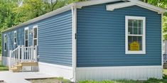 a small blue house with white trim and windows