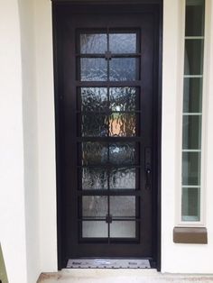 a black front door with glass panels on the side