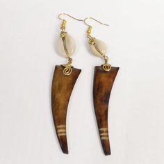 Overview Animal Tooth Inspired Ox Horn Earrings with Cowries
Channel the wild beauty of nature with the Animal Tooth Ox Horn Earrings, expertly handcrafted from natural ox horn.

These striking earrings are designed to mimic the look of animal teeth, offering a unique and bold accessory.

Perfect for adding a statement to your everyday wear or elevating a formal look, the Animal Tooth Inspired Ox Horn Earrings blend natural materials with cultural craftsmanship, making them a must-have for any jewelry collection.
Why You’ll Love Our Animal Tooth Ox Horn Earrings:

 	Handcrafted from natural ox horn, offering a bold and earthy design
 	Inspired by the natural elegance of animal teeth, symbolizing strength and style
 	Lightweight and comfortable, ideal for all-day wear
 	A unique accessory f Earthy Design, Animal Teeth, Horn Earrings, Wild Beauty, Bold Accessories, Formal Looks, Accessories Unique, Unique Earrings, Ox