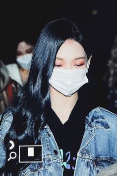 a woman wearing a face mask and denim jacket