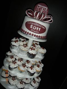 a three tiered cake with cupcakes on the bottom is decorated in red and white