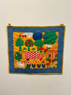 a quilted wall hanging on the side of a white wall