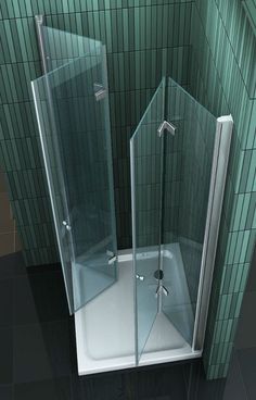 a glass shower stall in the corner of a tiled bathroom with green tiles on the walls