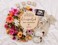 a baby announcement surrounded by flowers and shoes