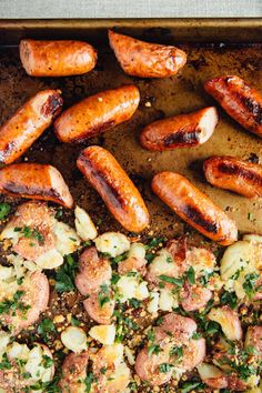 sausages and potatoes on a baking sheet ready to be cooked in the oven for dinner