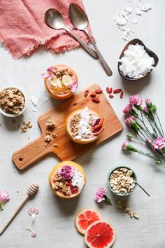 bowls of granola, yogurt and grapefruit on a cutting board