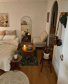 a bed room with a neatly made bed next to a chair and table in front of a mirror