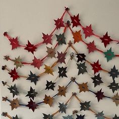 a christmas tree made out of red, white and blue paper stars hanging on a wall