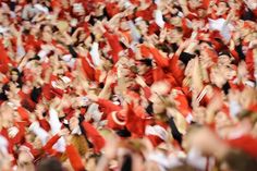 a large group of people with their hands in the air