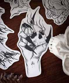 some stickers on a wooden table next to a white skull and other things in the background