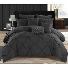 a bed with black comforter and pillows