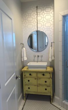 a bathroom with a sink, mirror and shower stall