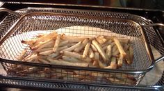 french fries are sitting in a basket on the counter top, ready to be cooked