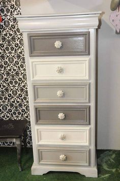 a white and gray dresser with flowers on the drawers