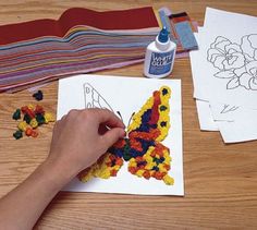 someone is working on an art project with crochet flowers and butterfly shapes in the background