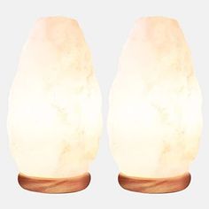 two white himalayan salt lamps on wooden bases