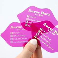 three pink business cards in the palm of a person's hand with white nails