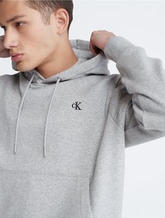 Made from a soft cotton blend, this fleece hoodie offers ultimate comfort for everyday wear. Designed with long sleeves and a kangaroo pocket at the front. Finished with CK monogram logo embroidery at the upper chest.  Material: 80% Cotton, 20% Polyester. Classic Hoodie Sweatshirt With Double-lined Hood, Classic Hoodie With Double-lined Hood, Basic Cotton Hoodie With Pockets, Heather Grey Hooded Sweatshirt With Kangaroo Pocket, Gray Long Sleeve Hoodie With Embroidered Logo, Basic Fall Hoodie With Kangaroo Pocket, Fall Basic Hoodie With Kangaroo Pocket, Classic Long Sleeve Hoodie With Drawstring, Heather Grey Hoodie Sweatshirt With Pockets