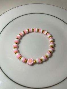 a pink and gold beaded bracelet on a white plate