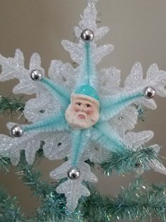 a christmas ornament hanging from a tree with snowflakes and ornaments on it