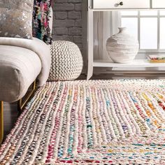 a white rug with multicolored crochet on it in front of a window