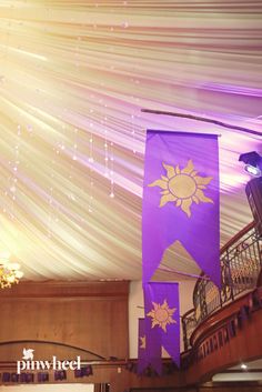 purple banners hanging from the ceiling in a large room with chandelier and lights