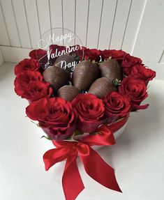 valentine's chocolates in a heart shaped box with red roses and a happy valentine's day sign