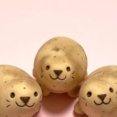 three ceramic animals sitting next to each other on a pink surface