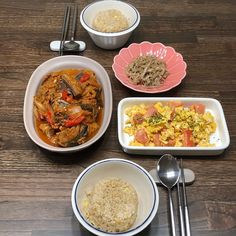 various bowls and dishes with rice, meat and vegetables in them on a wooden table