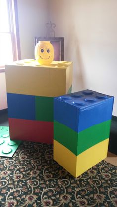 two lego blocks sitting on top of a carpet next to each other in front of a window