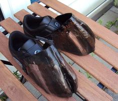 two black shoes sitting on top of a wooden bench