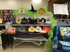 there are many items on the table for sale at this halloween event, including hats and scarves