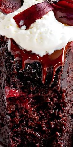 a close up of a piece of cake on a plate with whipped cream and cherries