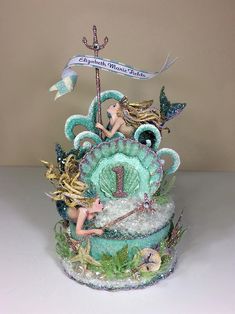 there is a cake decorated with mermaids and sea creatures on it's side