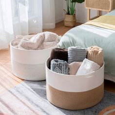 two baskets with towels and blankets are on the floor