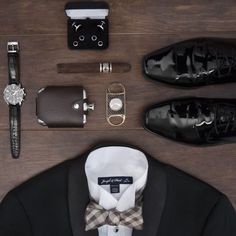 men's accessories laid out on top of a wooden table