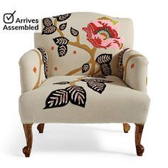 an upholstered chair with floral designs on the armrests and foot rest