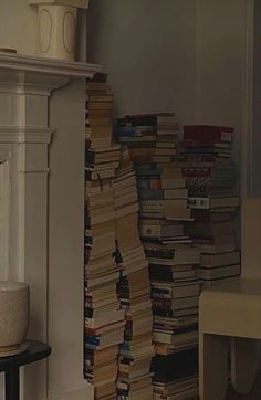 a stack of books sitting next to a fireplace