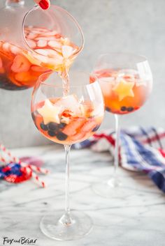 two glasses filled with red, white and blue sangria sitting on top of a table