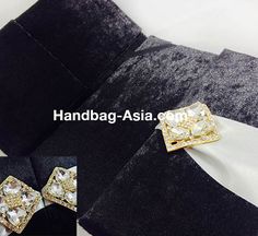 the black and white suit is adorned with gold brooches