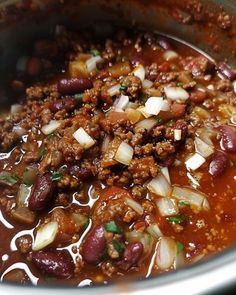 a pot filled with chili and beans on top of a stove