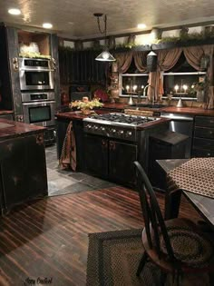 a kitchen with wooden floors and black cabinets is lit up by lights on the ceiling