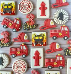 decorated cookies with fire trucks and firetrucks are on a white wooden surface