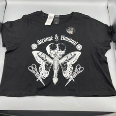 Cosmic Aura Strange & Unusual Glow-In-The-Dark Crop T-Shirt Small Something Strange And Unusual Is Fluttering Into Your Wardrobe! Turns Some Heads With This Tee, Featuring A Butterfly Creature With A Spinal Center And Two Skulls, Plus "Strange & Unusual" In A Gothic Font Up Top. Wander Into The Dark To Watch This Tee Glow! * 100% Cotton * Wash Cold; Dry Low * Length: 17" * Glows In The Dark * Imported Punk Graphic Print Top For Music Festival, Punk Style Tops With Graphic Print For Music Festival, Fitted Trendy T-shirt With Skull Print, Punk Crop Top For Festivals, Punk Style Crop Top For Festival, Edgy Halloween Graphic Print Tops, Black Halloween Concert Top, Fitted Punk Tops With Graphic Design, Black Halloween Crop Top For Streetwear