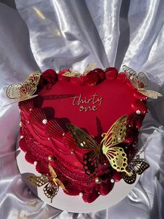 a red heart shaped cake with butterflies on it and the words happy valentine's day