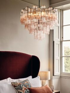 a chandelier hanging from the ceiling over a bed