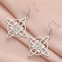 Bring strength, protection, and happiness into your life with our Witch Knot Earrings. These stainless steel earrings feature the powerful Witch's Knot design, symbolizing the circle of life, and a delicate rose representing beauty and love. Embrace your inner witch with this protective and enchanting jewelry. 🧙🏻‍♀️🔮🌹 Tarnish Resistant Rose Gold Stainless Steel Earrings, Symbolic Tarnish-resistant Silver Earrings, Symbolic Silver Tarnish Resistant Earrings, Symbolic Silver Tarnish-resistant Earrings, Tarnish Resistant Surgical Steel Earrings As A Gift, Tarnish Resistant Surgical Steel Earrings, Symbolic Stainless Steel Jewelry, Surgical Steel Drop Earrings As Gift, Surgical Steel Drop Earrings For Gift