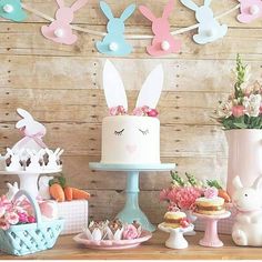 a table topped with lots of cakes and bunnies